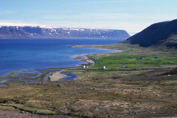 Weit unten in der Bucht die verlassenen Häuser von Hesteyri in den Westfjorden Islands