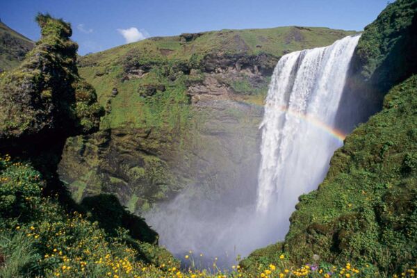 Der imposante Wasserfall Skogafoss mit Regenbogen